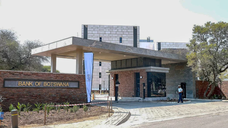 Entrance of the bank of botswana headquarters with security personnel and modern office buildings in the background