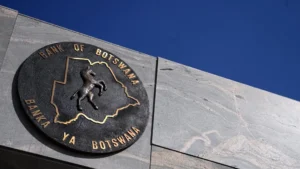 Bank of botswana seal on building wall showing a zebra inside botswanas map outline with blue sky background