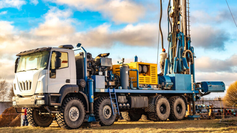 Heavy duty mobile drilling truck with mounted rig operating at an open field site