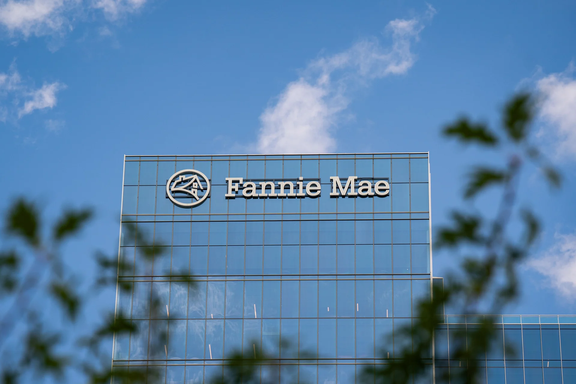 Fannie mae headquarters building with logo on glass facade against a blue sky representing u S Housing finance and mortgage support