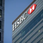 HSBC headquarters building with logo illuminated at dusk in Canary Wharf, London.