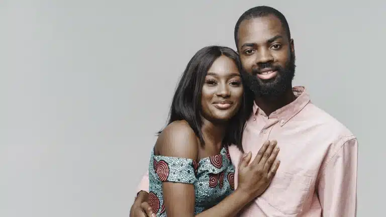 Smiling African couple posing together in a studio, showing affection and togetherness.
