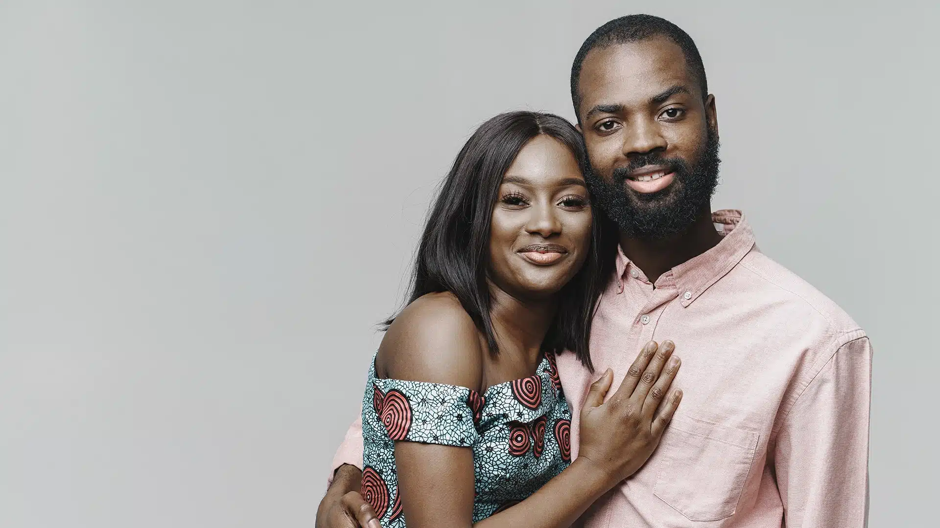 Smiling african couple posing together in a studio showing affection and togetherness