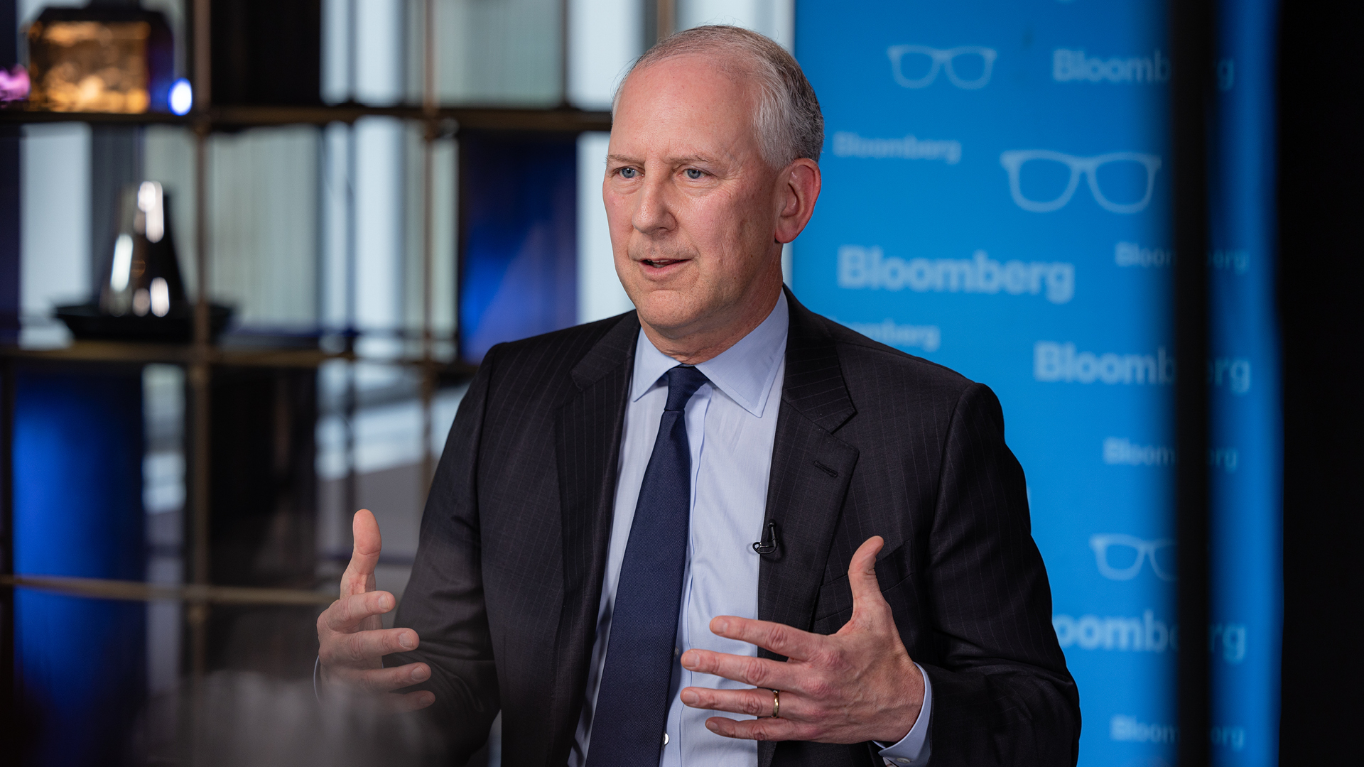 Peter Zaffino — CEO of AIG in Conversation with Bloomberg | Brimco Peter zaffino ceo of aig speaking during an interview at bloombergs studio wearing a dark suit and blue tie