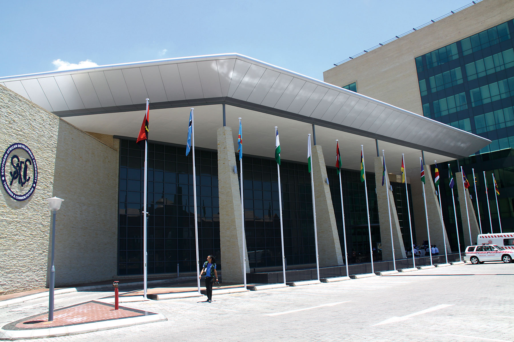 Front view of the sadc headquarters building in gaborone botswana with flagpoles displaying member state flags and a modern glass and brick architectural design