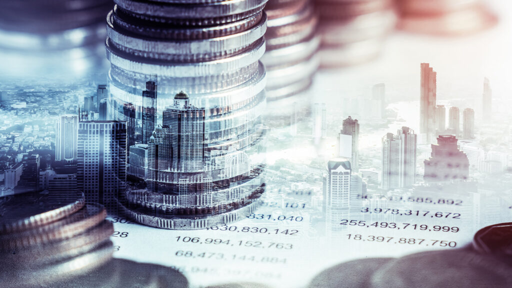 Overlay image of tall stacks of coins and a city skyline symbolizing financial growth investment and economic development