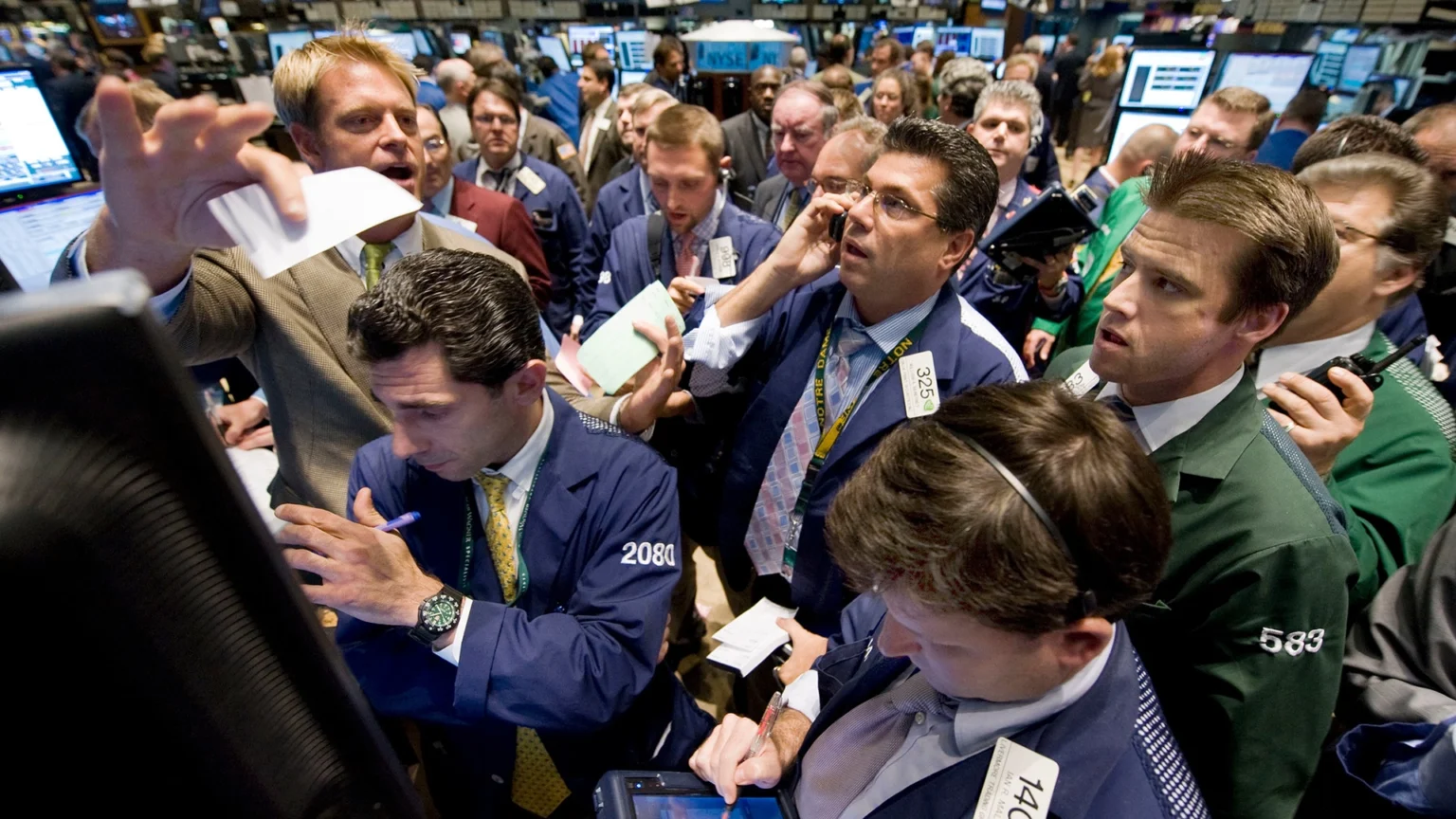 Traders on the floor of the new york stock exchange react to market volatility during the 2008 financial crisis