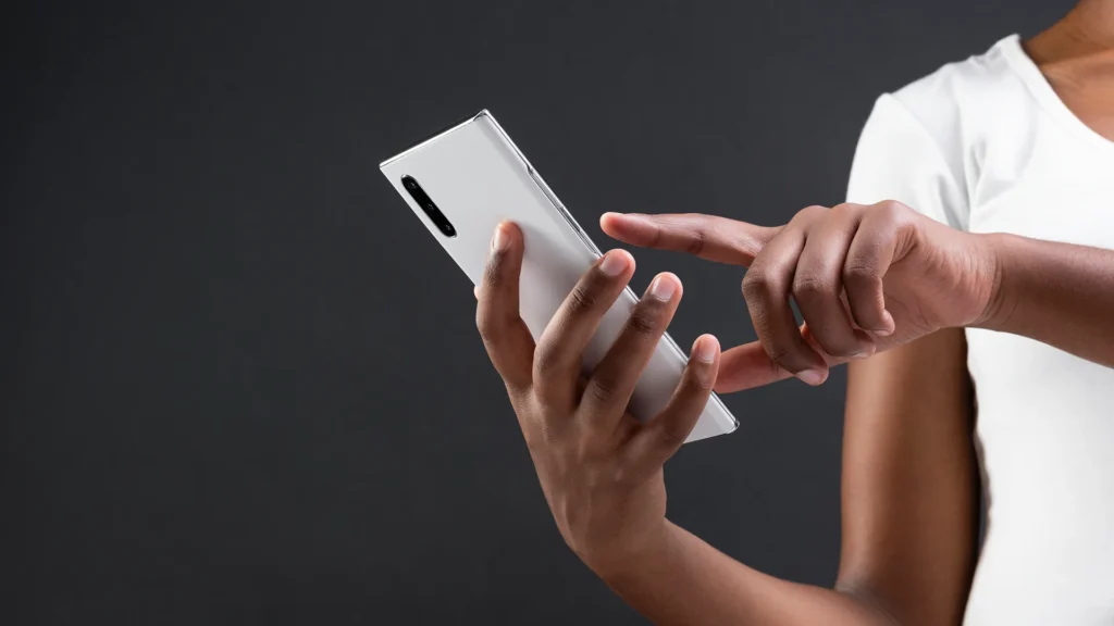 Person using a smartphone to design or plan a mobile app interface.