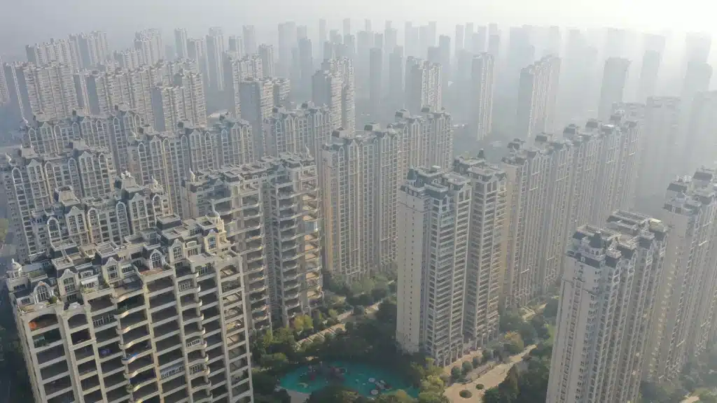Dense High-Rise Housing Complexes in Urban China | Brimco A vast cluster of tall residential apartment towers in a chinese city seen from above on a hazy day