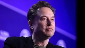 Elon musk addressing a global innovation and technology conference against a blue background