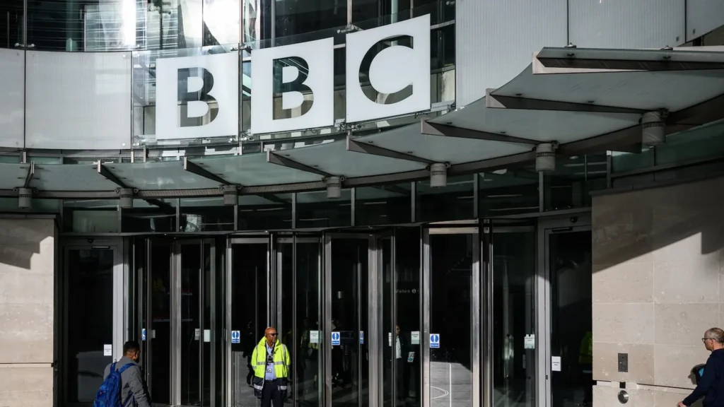 Entrance to BBC Broadcasting House in London | Brimco Exterior entrance of bbc broadcasting house with people walking and a security guard standing outside