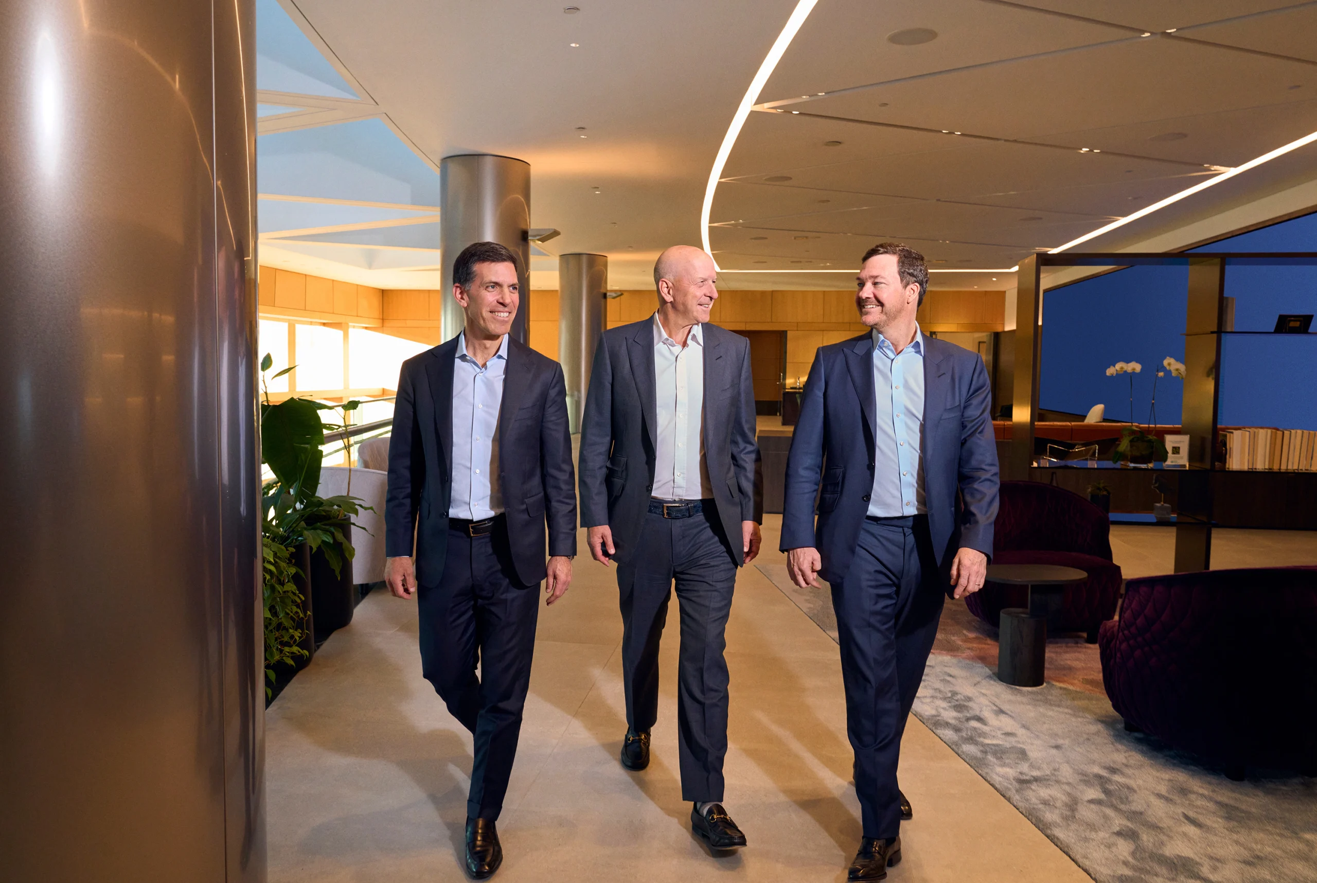 Goldman sachs leadership team walking together inside corporate headquarters in new york city