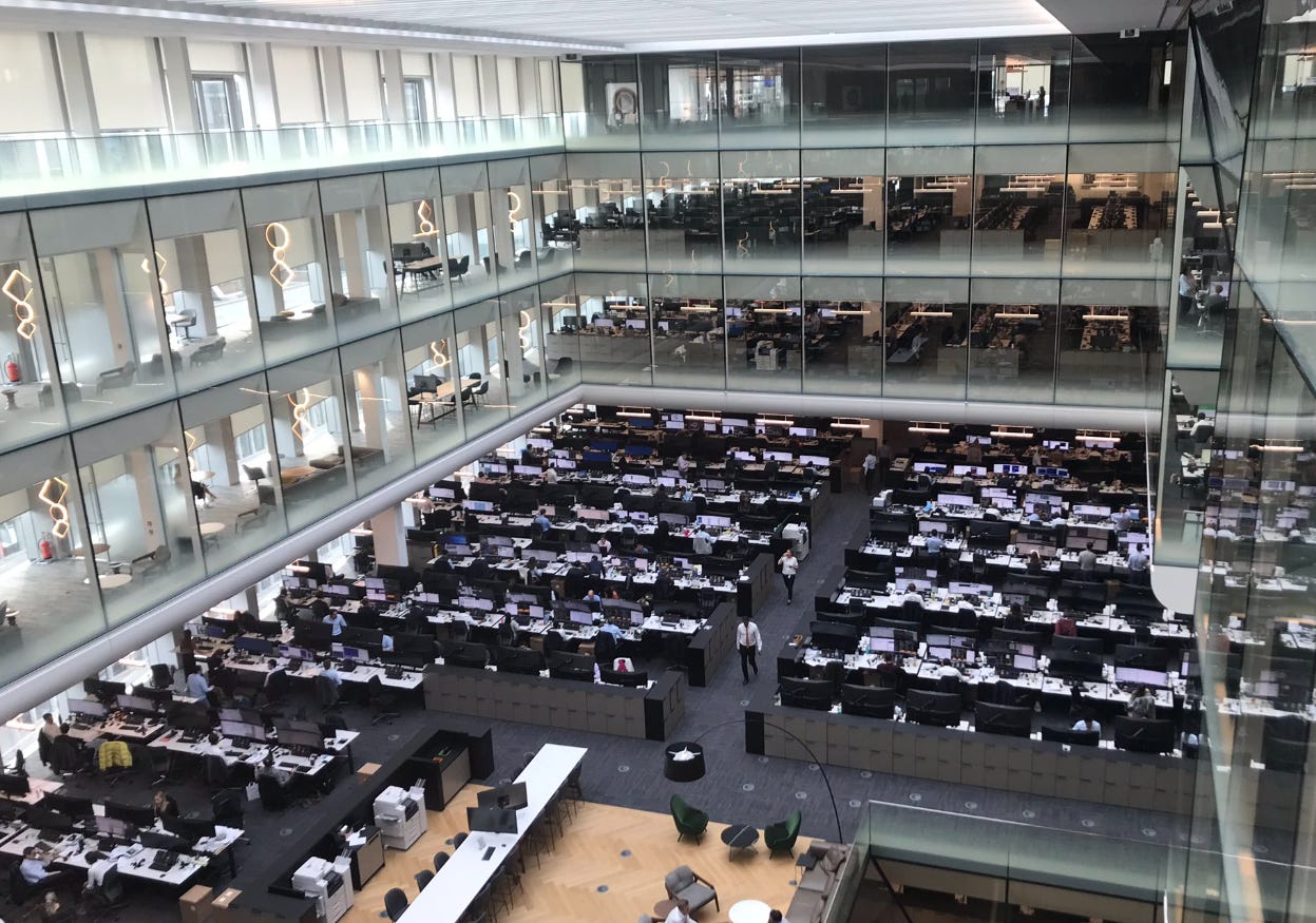 Interior view of goldman sachs trading floor with desks computers and financial analysts working inside a glass walled office building