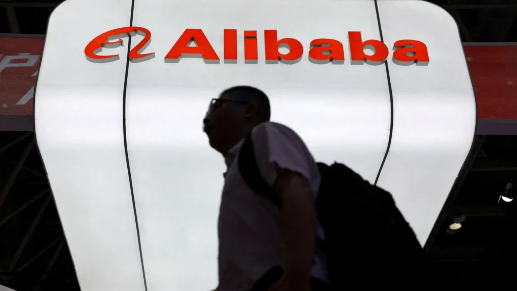 Alibaba Logo Display at Tech Expo | Brimco A large illuminated alibaba logo above a silhouetted person walking past at a technology exhibition
