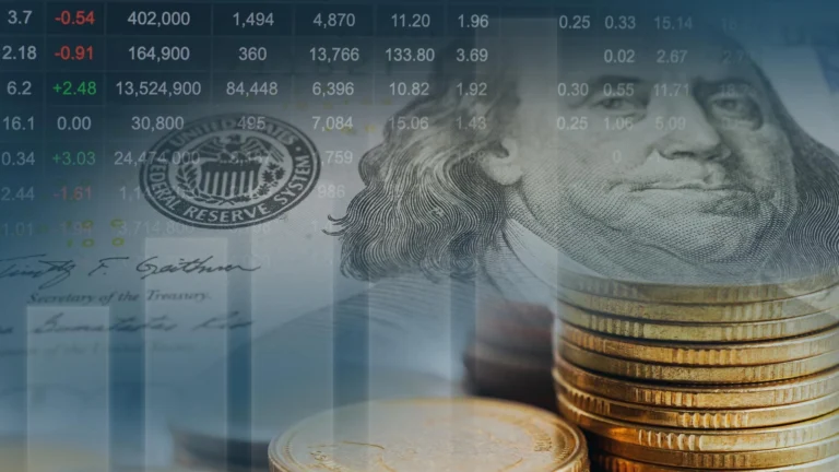 Close-up of stacked coins overlaid with a U.S. dollar bill and financial market data, symbolizing monetary policy and market performance.
