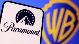A smartphone displaying the paramount logo in front of a blurred warner bros Discovery shield logo in the background