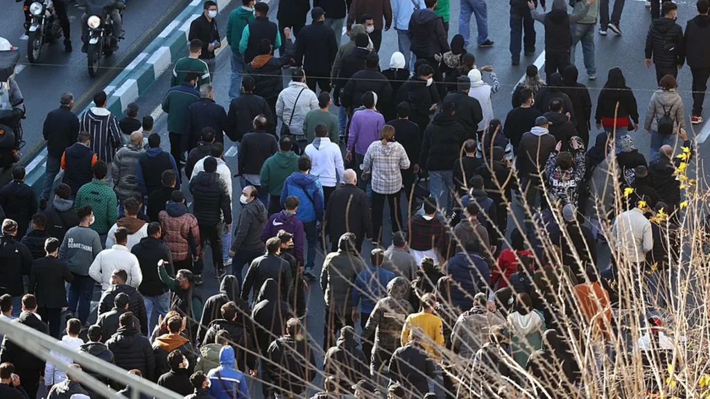 Crowds Gather During Iran Protests | Brimco Large crowds of people walking along a city roadway during a protest in iran viewed from above