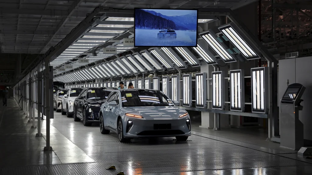 Inside Chinas Electric Vehicle Production Line | Brimco Electric vehicles move through a brightly lit automotive assembly line in a modern chinese factory with quality inspection stations and overhead displays