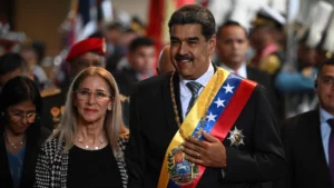 Venezuelas president nicolás maduro wearing the national sash walks beside his wife cilia flores during a formal state ceremony