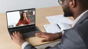 Business professional attending an online coaching session via video call on laptop